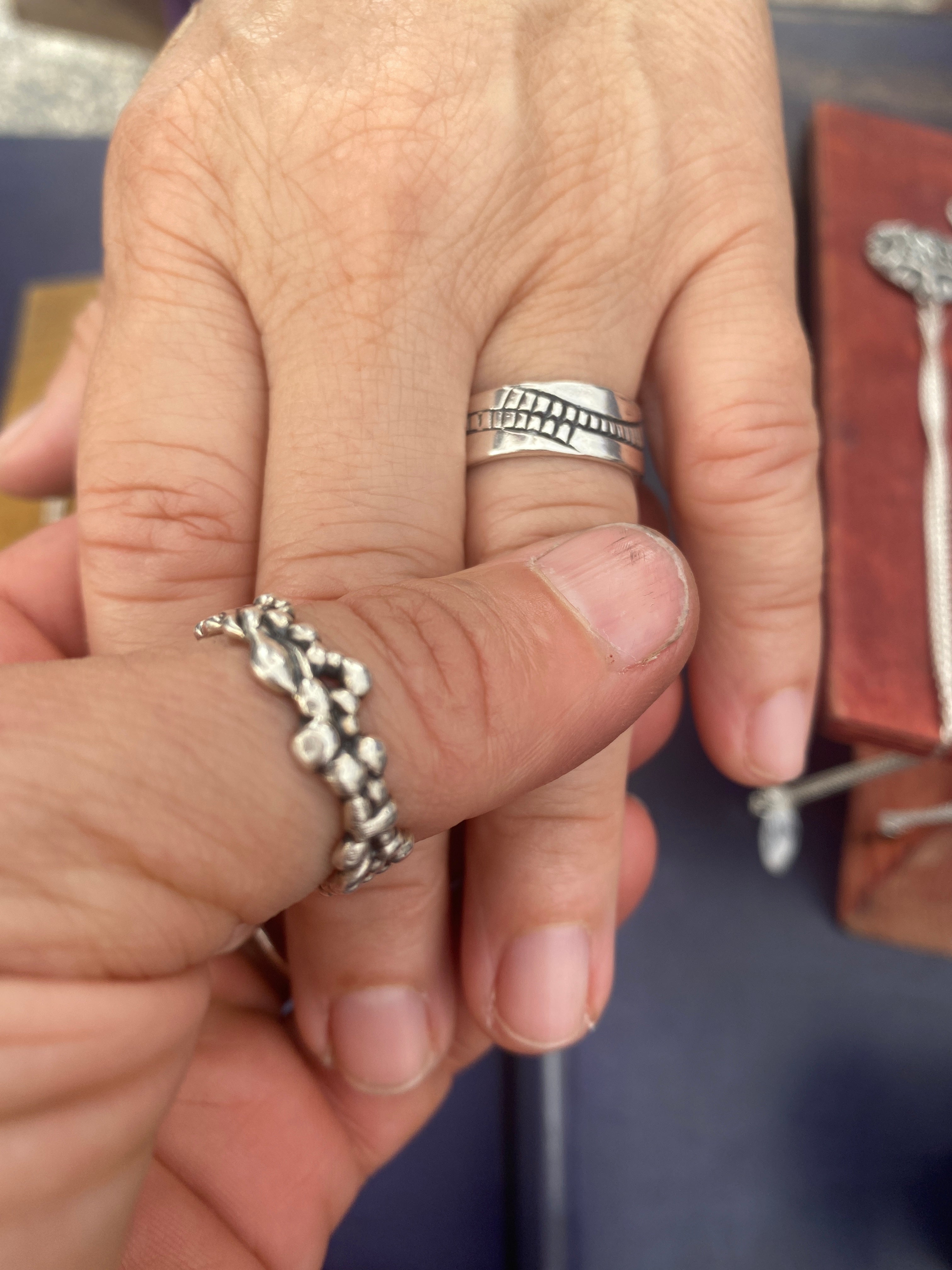 two hands connecting with two silver rings