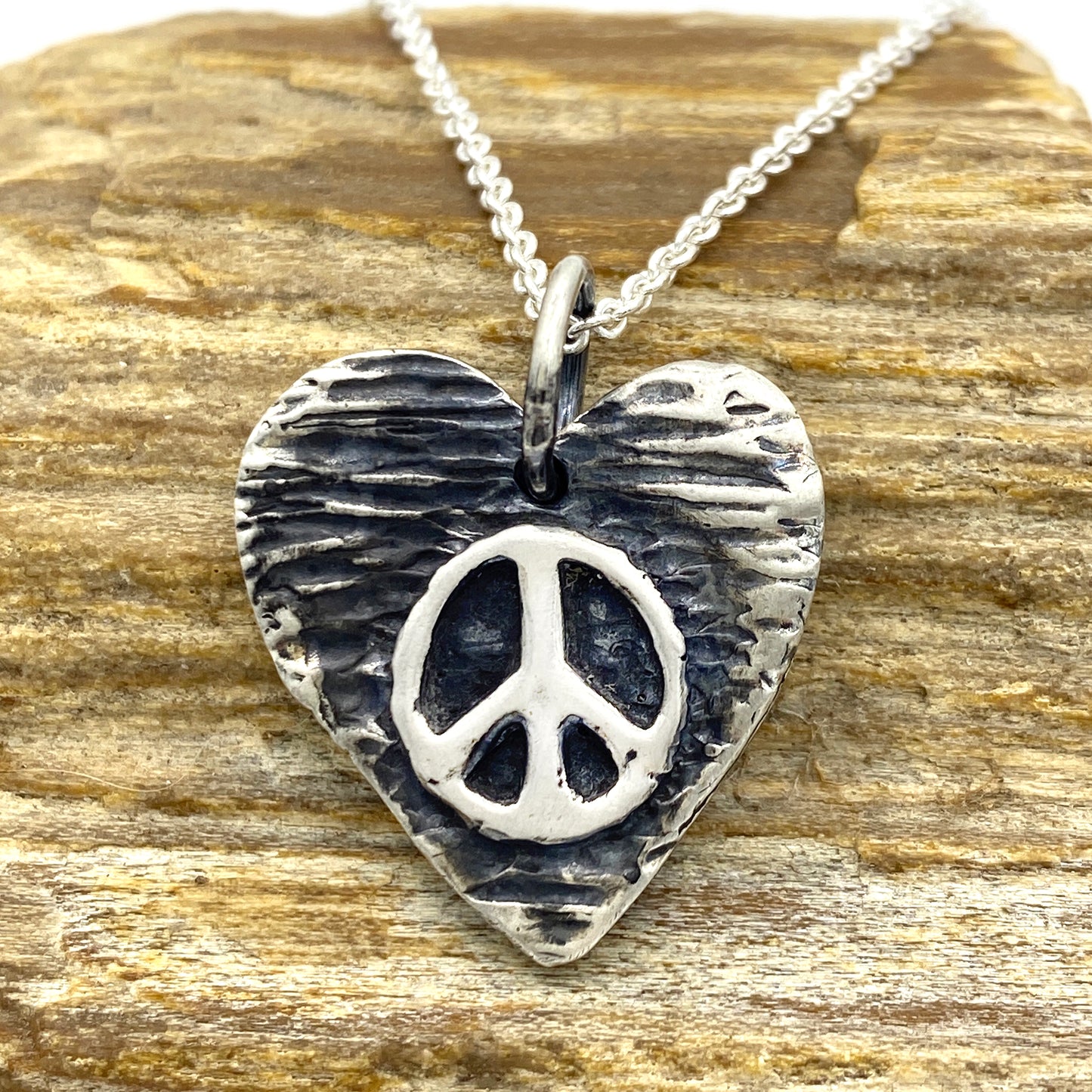 15mm x 15mm Heart shaped, textured pendant with a raised peace symbol in the middle, 5mm bail