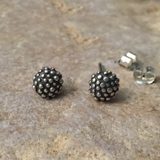 sterling silver ear studs textured with raised dots over a small domed pillow